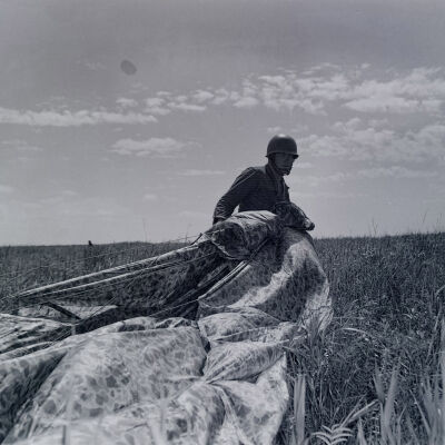 Paratrooper gathering his parachute after landing