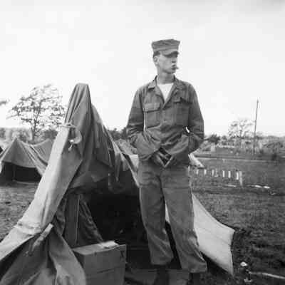 Soldier standing in front of tents