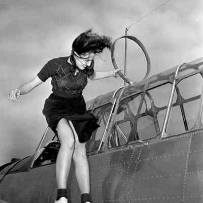 Woman posing on O-47 aircraft wing
