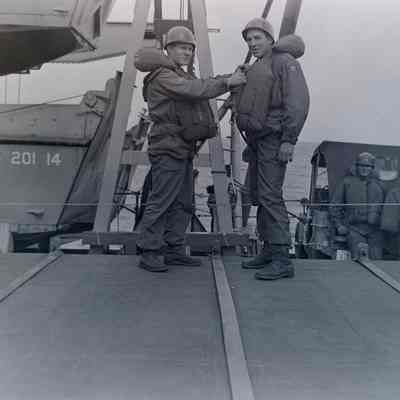 Soldiers checking their life jackets onboard a ship