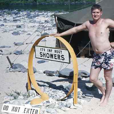 Soldier posing next to showers
