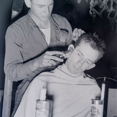 Soldier giving a haircut by candlelight