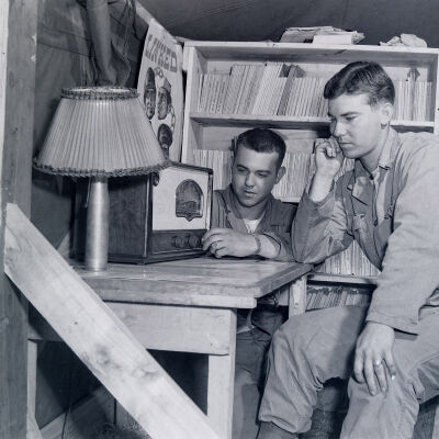 Two soldiers listening to radio in barracks library