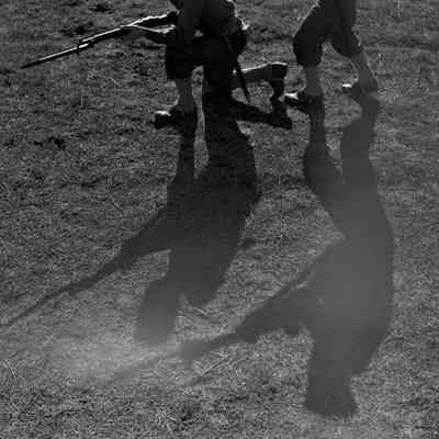 Shadows cast by soldiers brandishing weapons