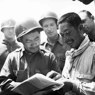 Japanese man laughing with soldiers