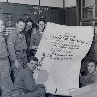 Soldiers with a banner celebrating Air Transportation Week from the citizens of Ardmore, OK