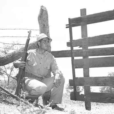 Soldier with his rifle next to gate