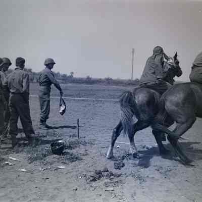 Soldiers leaving the starting gate on a horse race