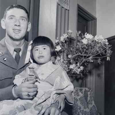 Portrait of a soldier with a small Japanese child on his lap