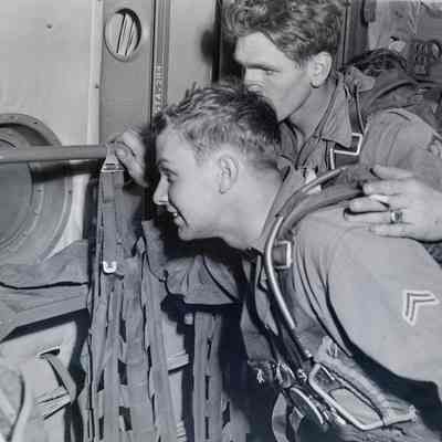 Two paratroopers looking out the window of a C-119