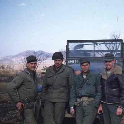 Soldiers standing in front of truck