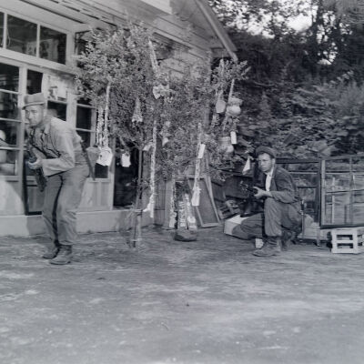 Two soldiers in fighting positions in front of a building