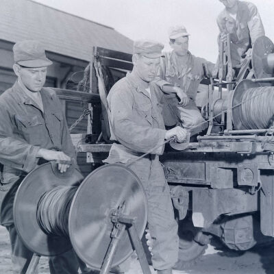 Soldiers spooling wire into back of truck