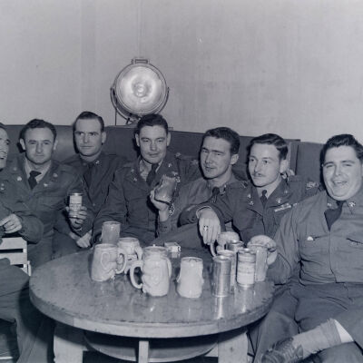 Group of soldiers sitting around a table enjoying their beer