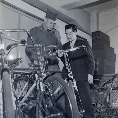 Soldier and Japanese civilian looking at new bicycles