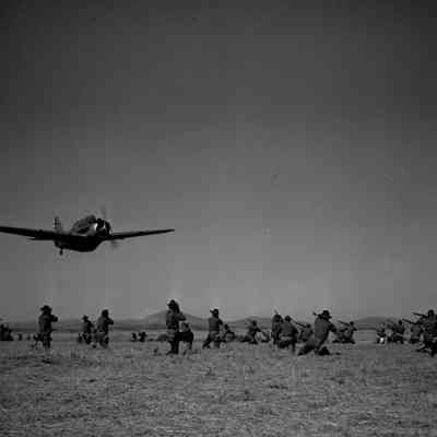 Soldiers aiming their rifles at airplane