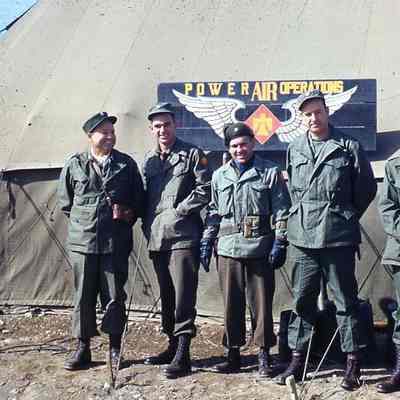 Soldiers standing in front of sign