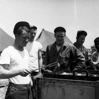 Soldier grilling steaks