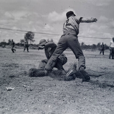 Soldier sliding to base during baseball game
