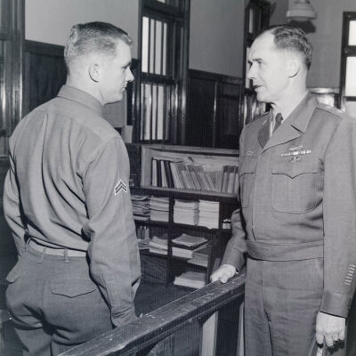 General talking with a Corporal in an office