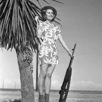 Woman posing with automatic rifle
