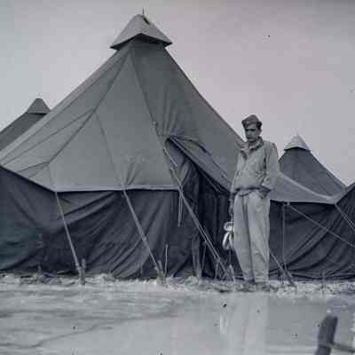 Soldier standing in front of tents