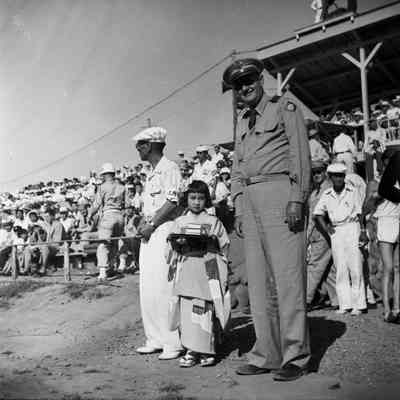 General Styron with a Japanese man and child at a track athletics event