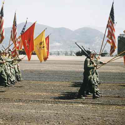 Soldiers marching during a review with flags