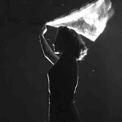 Night photo of a girl holding a scarf into the wind