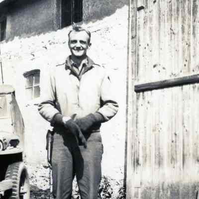 Officer standing in front of barn