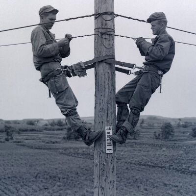 Two soldier linemen on a pole