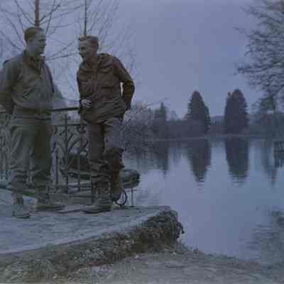 Two soldiers talking by a pond