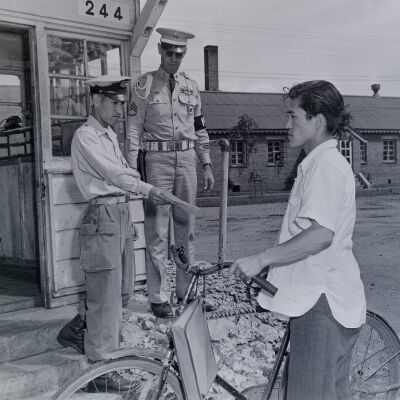 Military Police at camp gate checking civilian papers