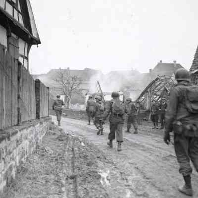 Soldiers marching through destroyed town