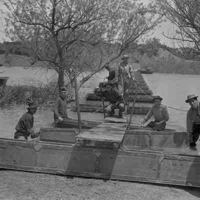 Soldiers constructing a pontoon bridge