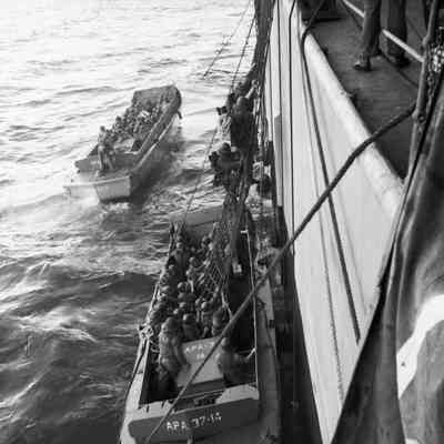 Soldiers climbing down nets into landing craft