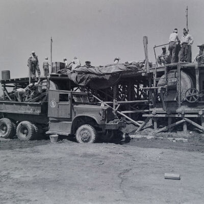 Civilians loading concrete into a truck at a batch plant