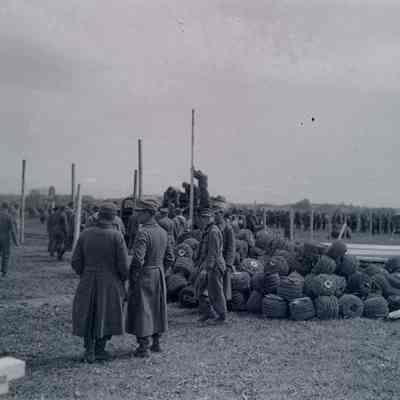 Soldiers and German prisoners working on a fence
