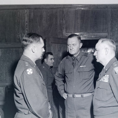 General Styron conferring with several generals at a meeting