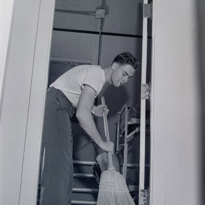 Soldier sweeping out a barracks