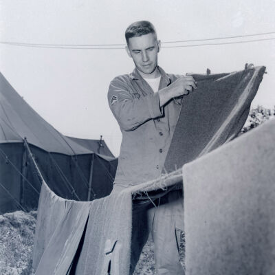 Soldier hanging laundry outside tent