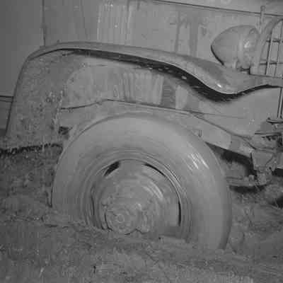 Front wheel of military truck moving through mud