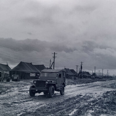 Jeep traveling a muddy road through camp