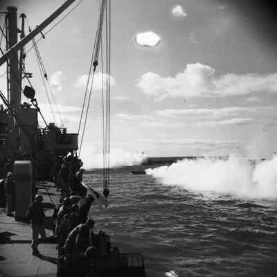 Landing craft lay smokescreen at sea