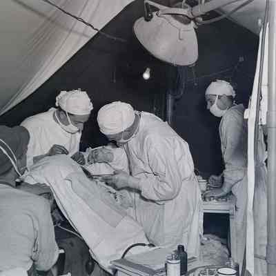 Surgeons operating on wounded soldier