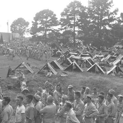 Soldiers lining up for mess call in a pup tent encampment