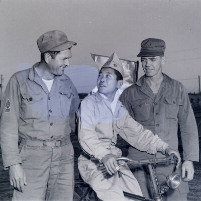Two soldiers with Japanese boy on bicycle