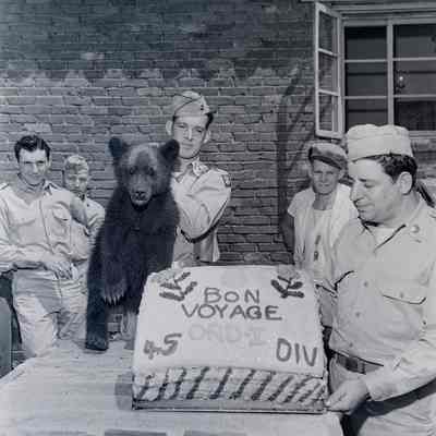 Soldiers and bear cub with cake