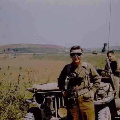 Soldier in Googles Poses in front of Jeep