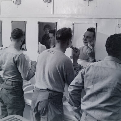 Soldiers shaving in barracks latrine